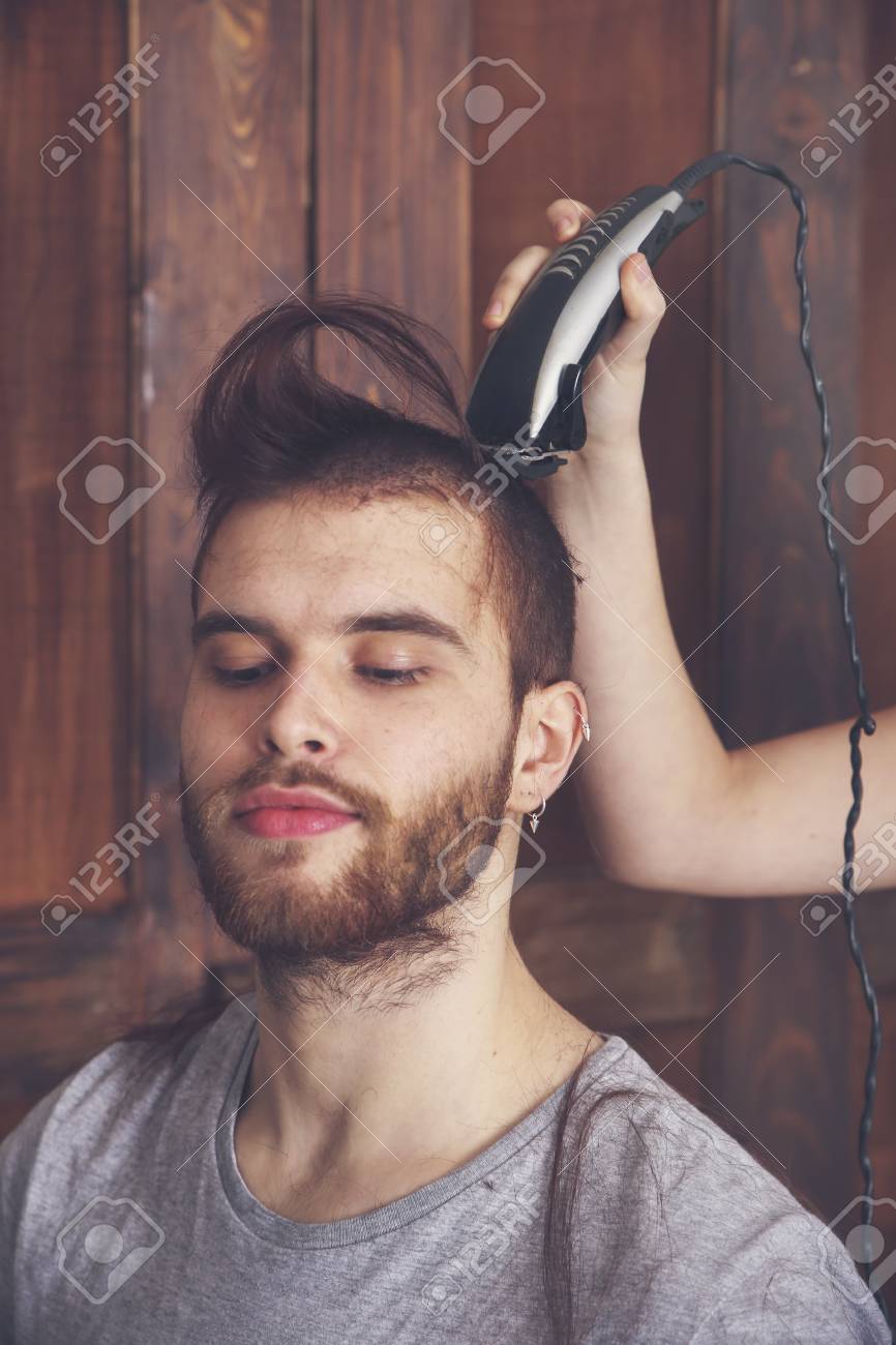 Portrait Of Young Man Getting A Haircut By His Girlfriend With