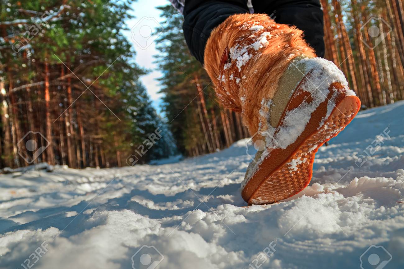 冬の公園を歩いている女性の足 暖かいブーツを履いた少女が雪の中を歩く 冬の靴のクローズアップ アウトソール 下から見る の写真素材 画像素材 Image