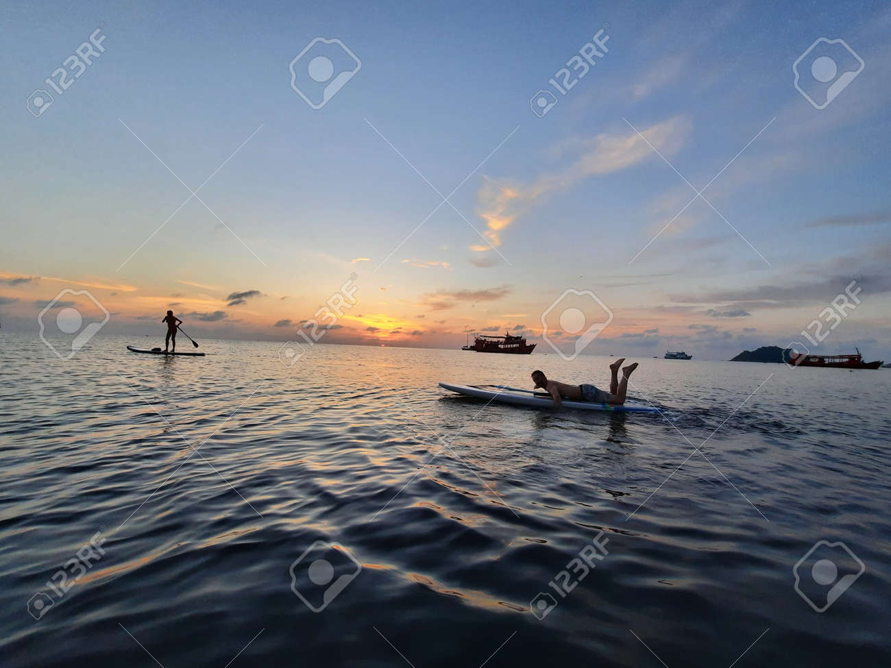 on a stand up paddle board, young man 34 years old, German, lies on a board on the ocean in Thailand, on the island Koh Tao at sunset - 169664548 on a stand up paddle board, young man 34 years old, German, lies on a board on the ocean in Thailand, on the island Koh Tao at sunset - 169664548