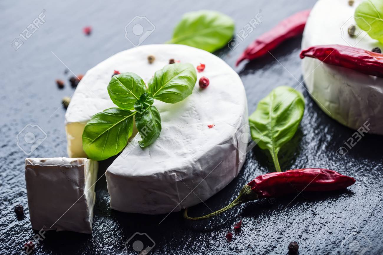 ブリーチーズ カマンベール チーズ 新鮮なブリーチーズ チーズとバジルの御影石ボードにスライス 4 色の胡椒と唐辛子の Pepers を葉します イタリア料理と地中海の食材 の写真素材 画像素材 Image