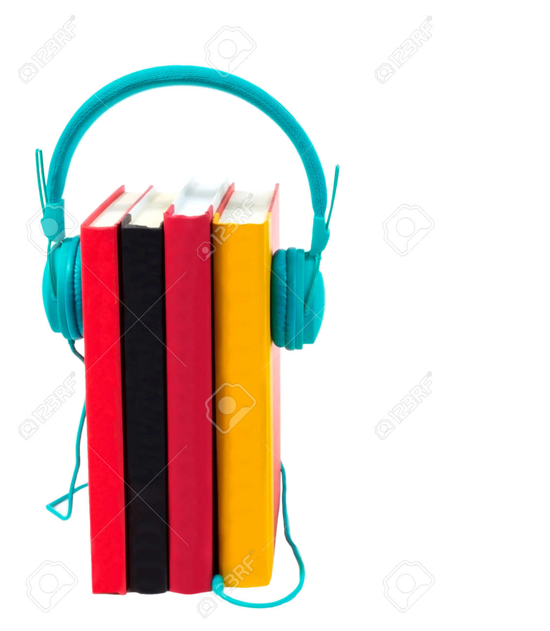 Vertical shot of four colorful books standing on end with a pair of turquoise headphones plugged into them. - 154411696 Vertical shot of four colorful books standing on end with a pair of turquoise headphones plugged into them. - 154411696