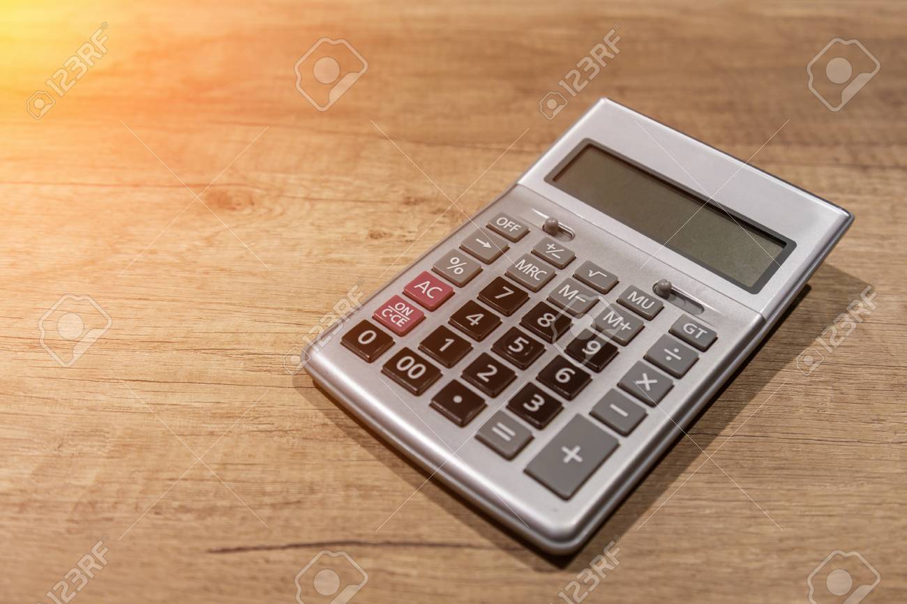 Press The Button On The Calculator With A Wooden Floor In The