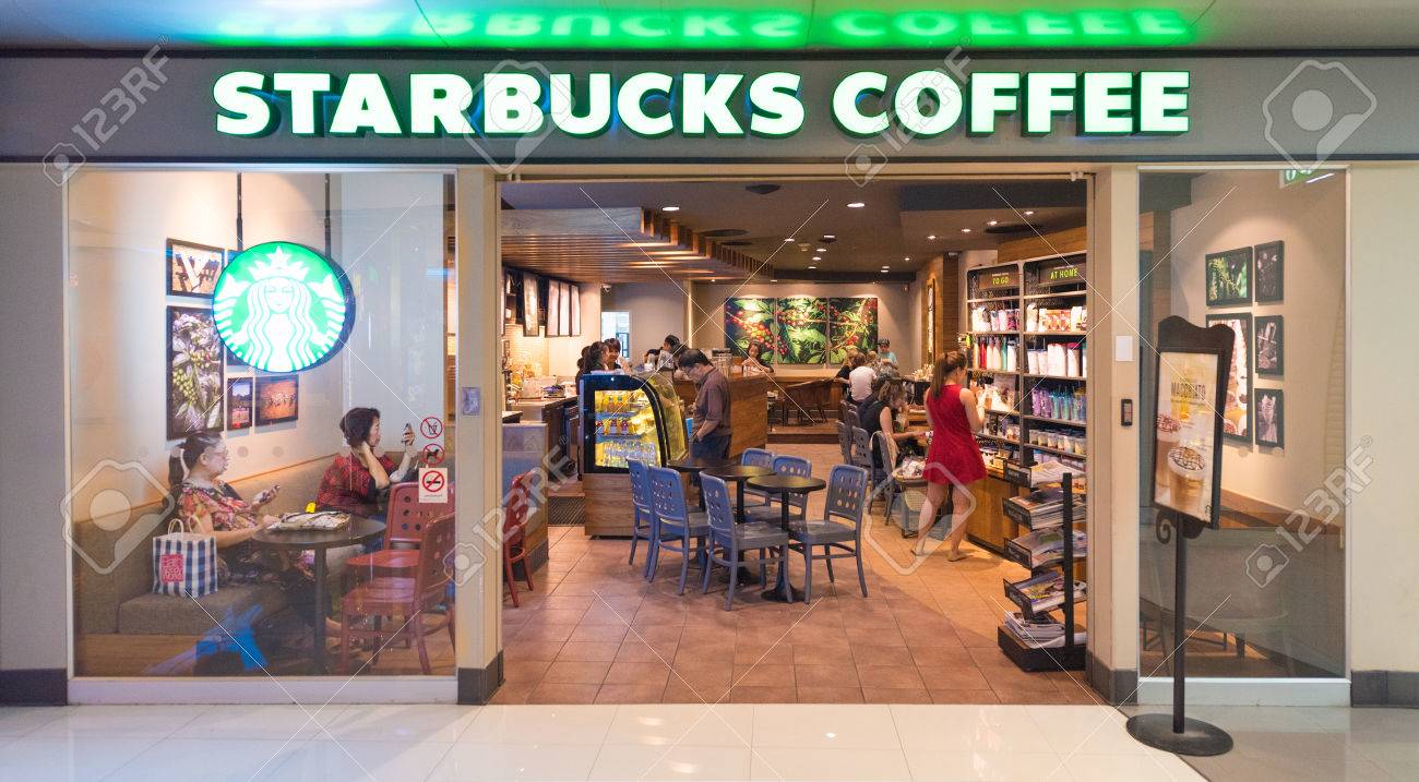 방콕 -2011 년 3 월 16 일 : 미확인 된 사람들이 MBK 쇼핑몰에있는 스타 벅스 커피점에서 마신다. Starbucks는 65  개국에 23,305 개의 매장을 보유한 세계 최대 커피 하우스 회사입니다. 로열티 무료 사진,