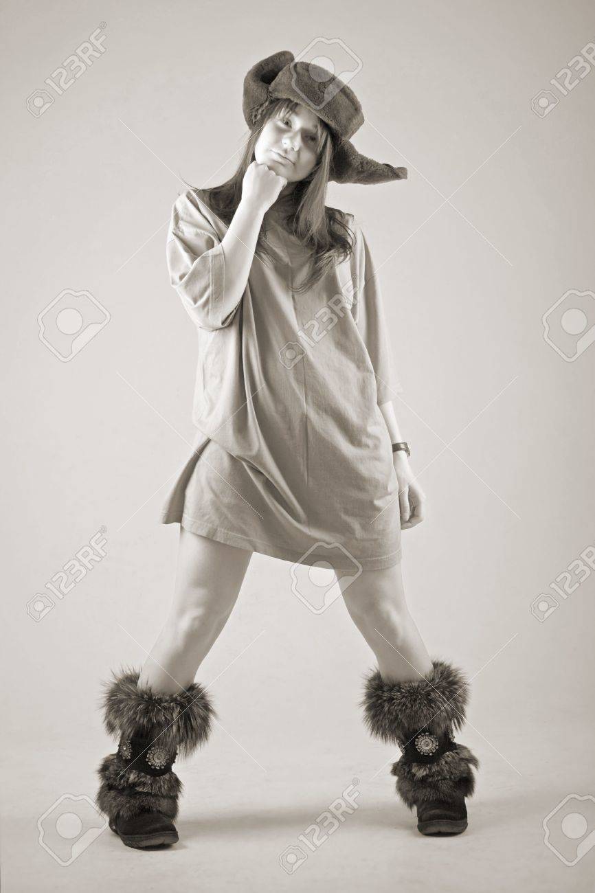 funny young woman in russian earflapped fur hat and fur boots