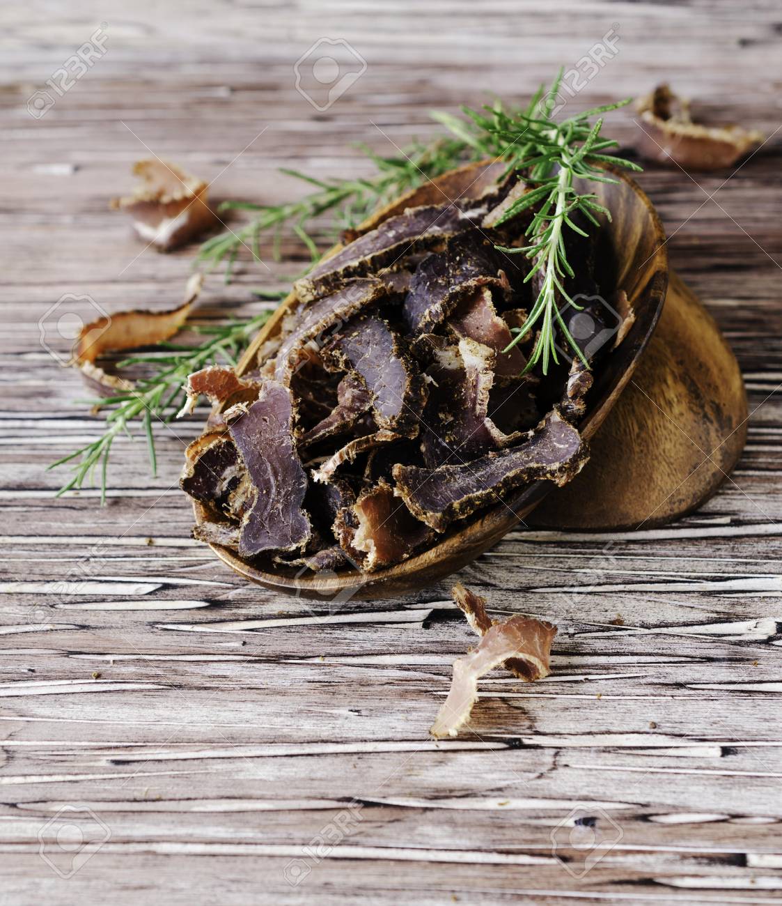 干し肉 牛 鹿 野生の獣や素朴なテーブルに木製のボウルに切り干し肉 の写真素材 画像素材 Image