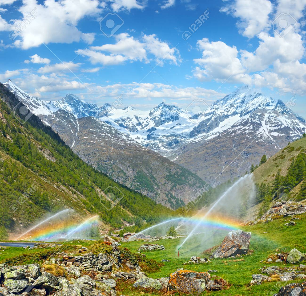 灌漑水の虹は 夏のアルプス山 スイス ツェルマット付近 で噴出します 2 つのショットは イメージをステッチします の写真素材 画像素材 Image