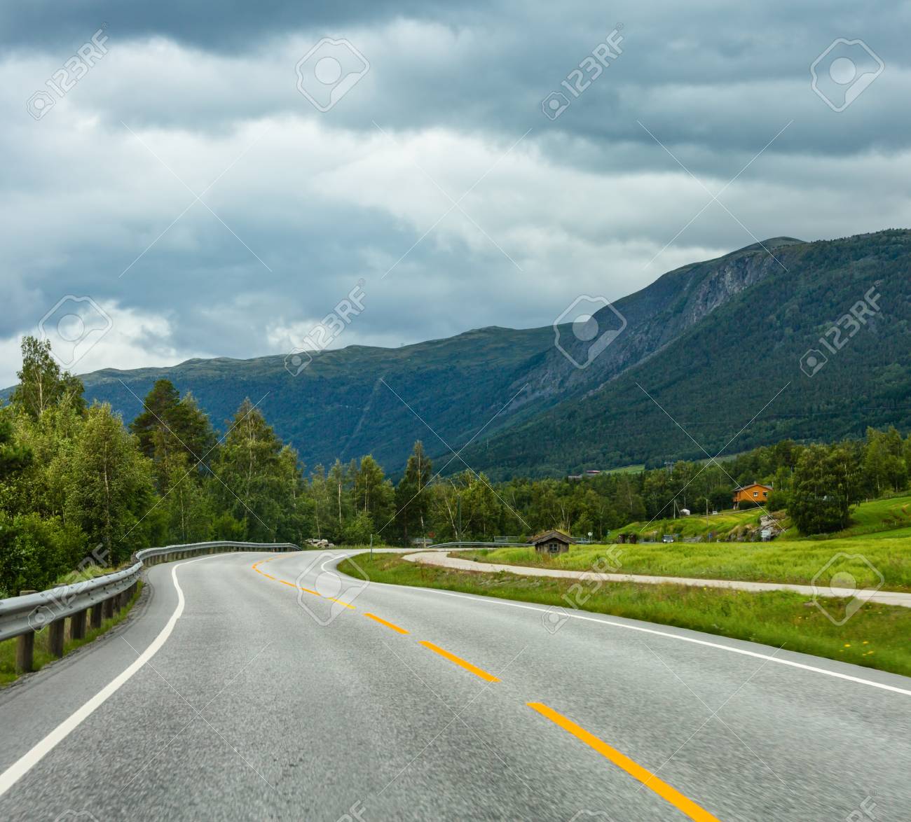 Summer cloudy mountain landscape with serpentine secondary road, Norway - 120986414 Summer cloudy mountain landscape with serpentine secondary road, Norway - 120986414