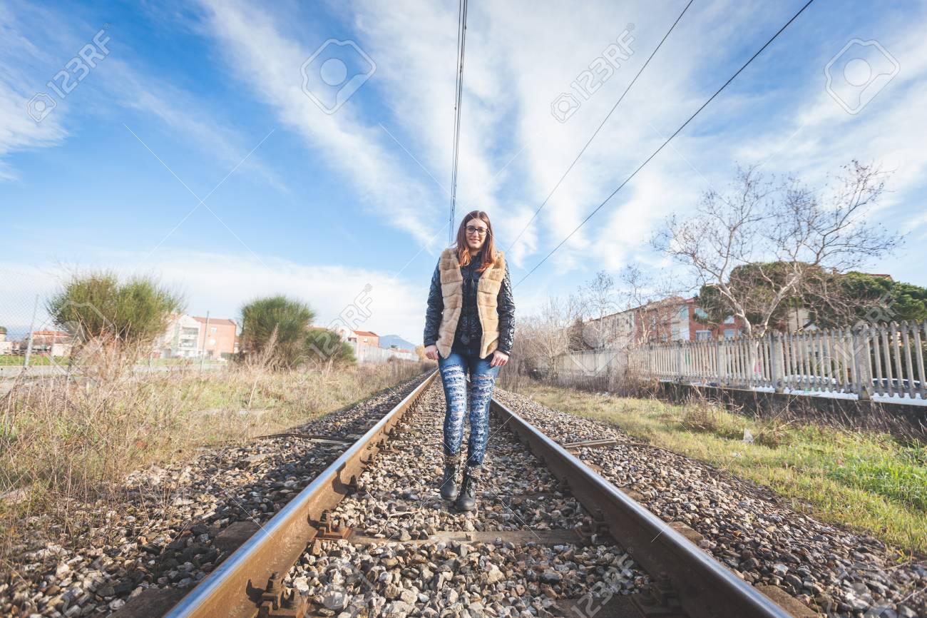 美しい若い女性が線路の上を歩きます 鉄道は 住宅 Aerea は 女の子がカジュアルな見ています の写真素材 画像素材 Image 美しい若い女性が線路の上を歩きます 鉄道は 住宅 Aerea は 女の子がカジュアルな見ています の写真素材 画像素材 Image