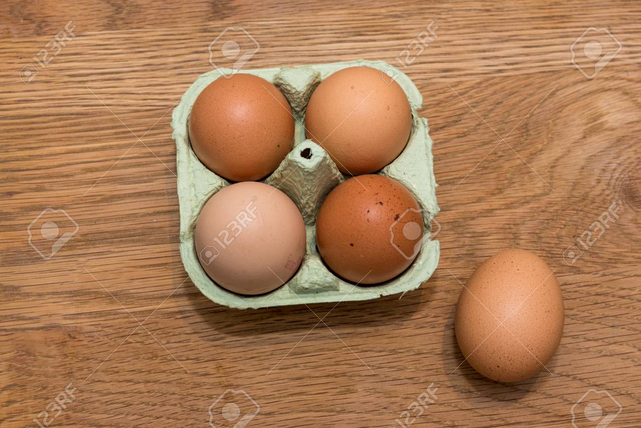 Close Up View Of Raw Chicken Eggs In Egg Box On Oak Wooden Background