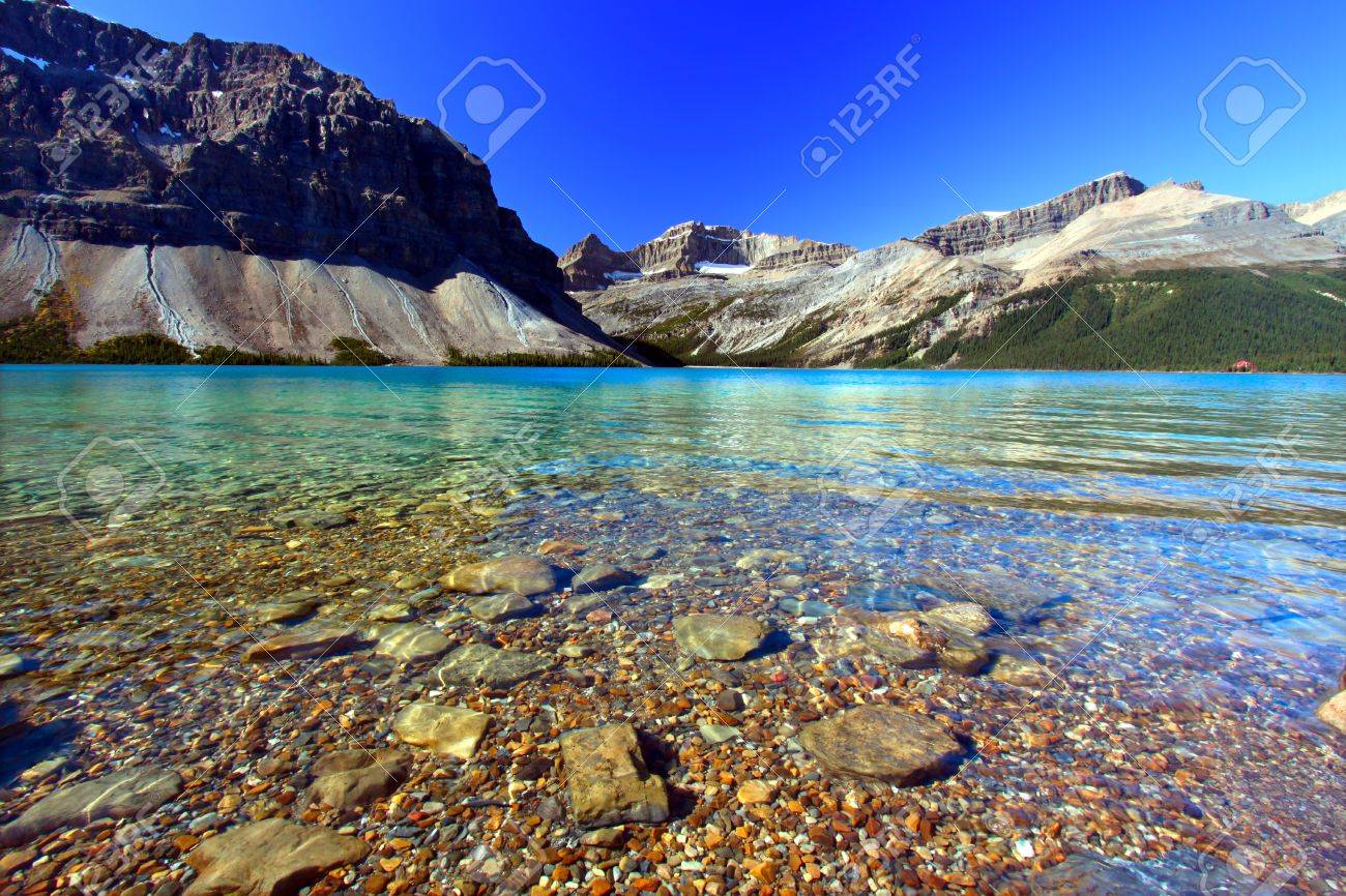 Rocky Substrate Visible Under Clear Waters Of Bow Lake In Banff - 