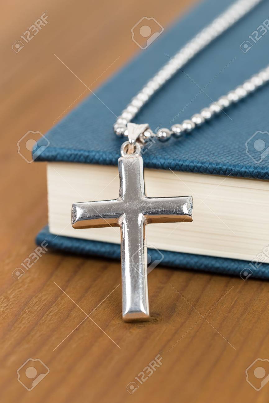 木製のテーブルと青い聖書本銀色の十字架ネックレス の写真素材・画像