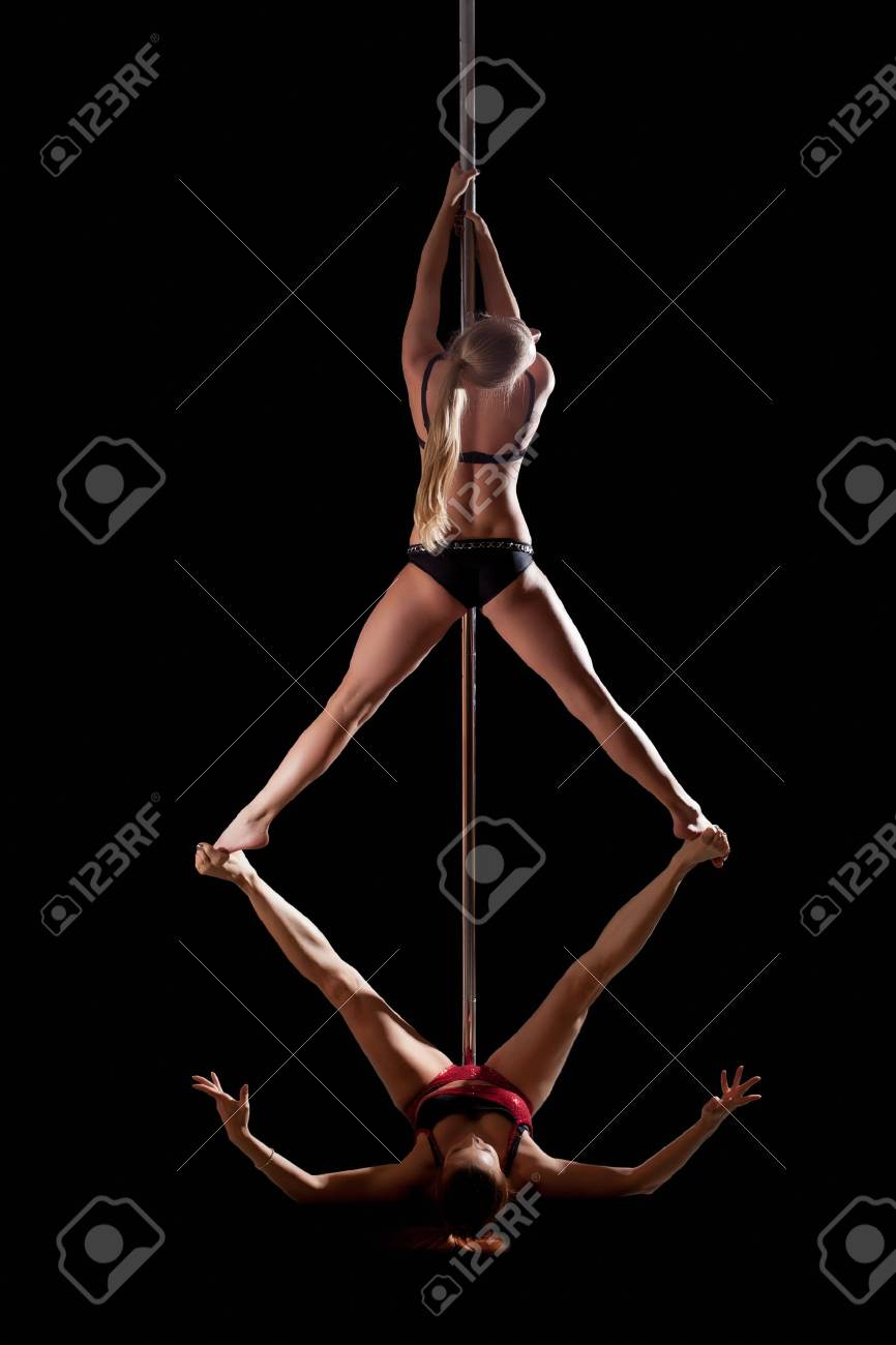 two women show high gymnastic level during pole dance isolated stock