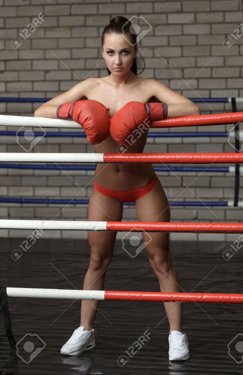 Topless brunette waiting for opponent in boxing ring - 45242267.