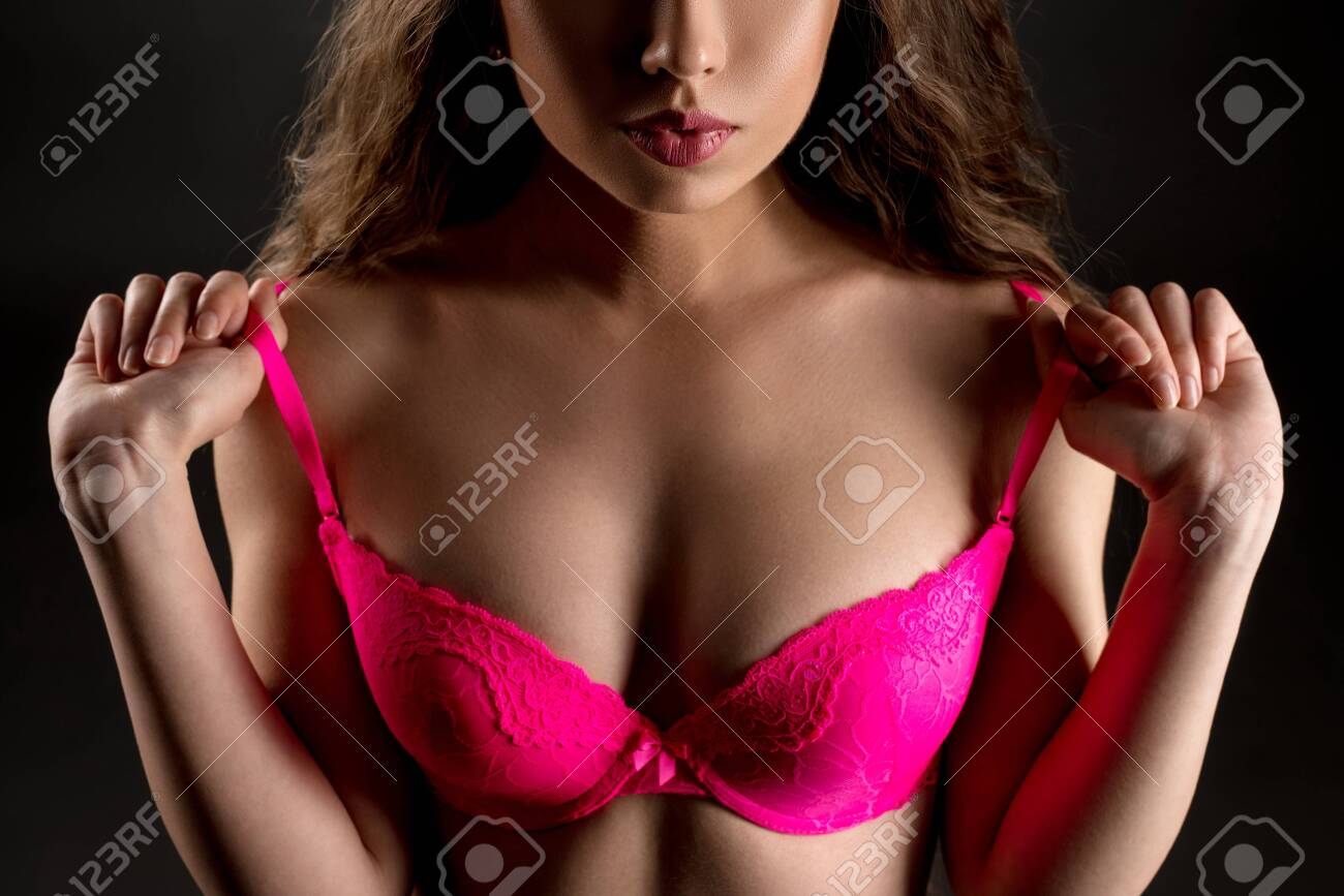 Woman Taking Off Her Bra Backwards Towards The Camera Stock Photo