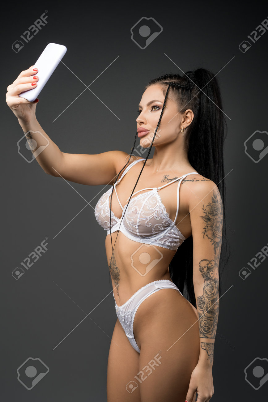 いやらしい体の女画像 スタジオでスマートフォンで自分撮りを撮るセクシーな女性の写真素材・画像素材 Image 183962275