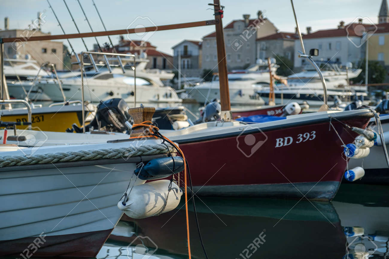 Budva, Montenegro, February 05, 2021: View of marina of the montenegrin town Budva. Motor boats, boats and yachts moored at the pier in the port. Old town center is visible on the background - 171119957 Budva, Montenegro, February 05, 2021: View of marina of the montenegrin town Budva. Motor boats, boats and yachts moored at the pier in the port. Old town center is visible on the background - 171119957
