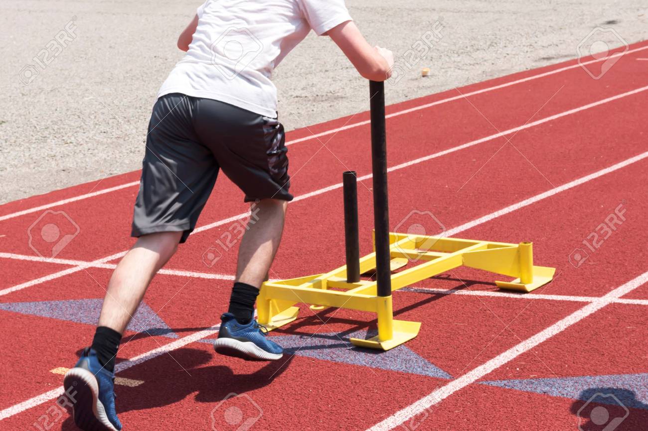 男子高校生は陸上練習で赤いトラックに黄色のそりをプッシュします の写真素材 画像素材 Image 82588400