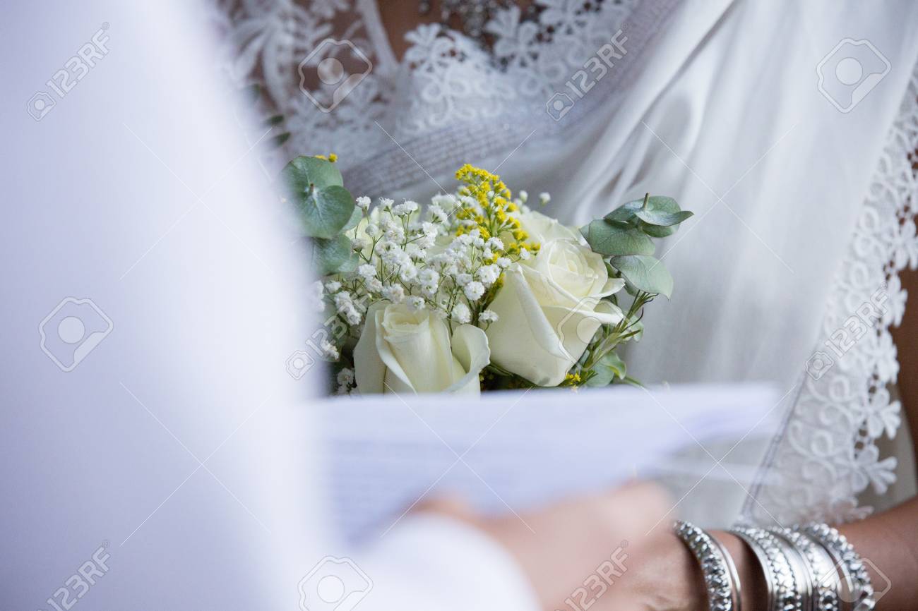 white roses bouquet between groom and bride grooms wedding vows