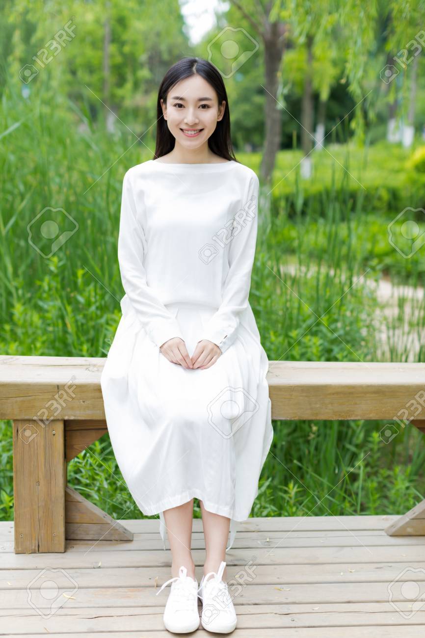 ベンチに座っている白いワンピースの女の子 の写真素材 画像素材 Image