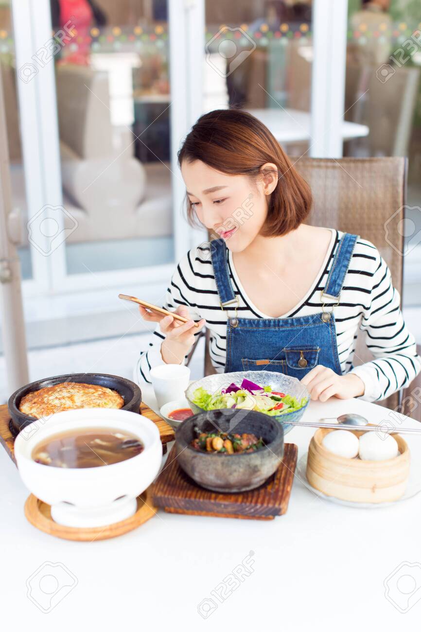 happy woman eating out in a restaurant,China. - 140677092 happy woman eating out in a restaurant,China. - 140677092
