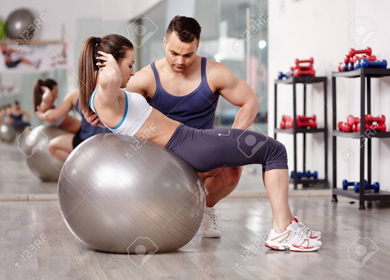 Personal Trainer Helping Woman Doing Abs Crunches With Gym Ball Stock Photo Picture And Royalty Free Image Image 27660381