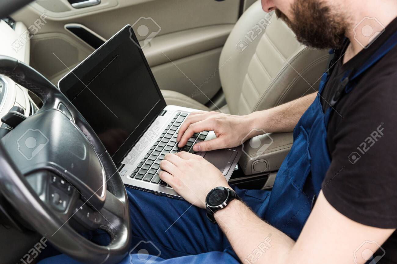Professional car mechanic working in auto repair service. Computer video investigate. Engine diagnostics. Service station - 142320642 Professional car mechanic working in auto repair service. Computer video investigate. Engine diagnostics. Service station - 142320642