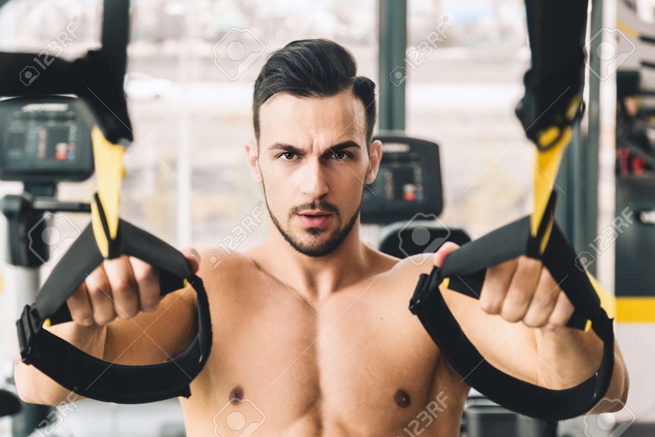 Handsome young sporty male bodybuilder with torso doing exercises in the gym - 171606167 Handsome young sporty male bodybuilder with torso doing exercises in the gym - 171606167