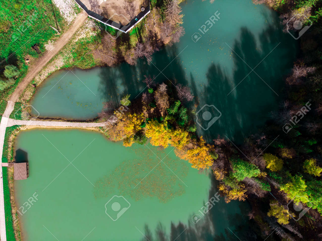 Top view of a beautiful blue lake among the autumn forest. - 171672546 Top view of a beautiful blue lake among the autumn forest. - 171672546