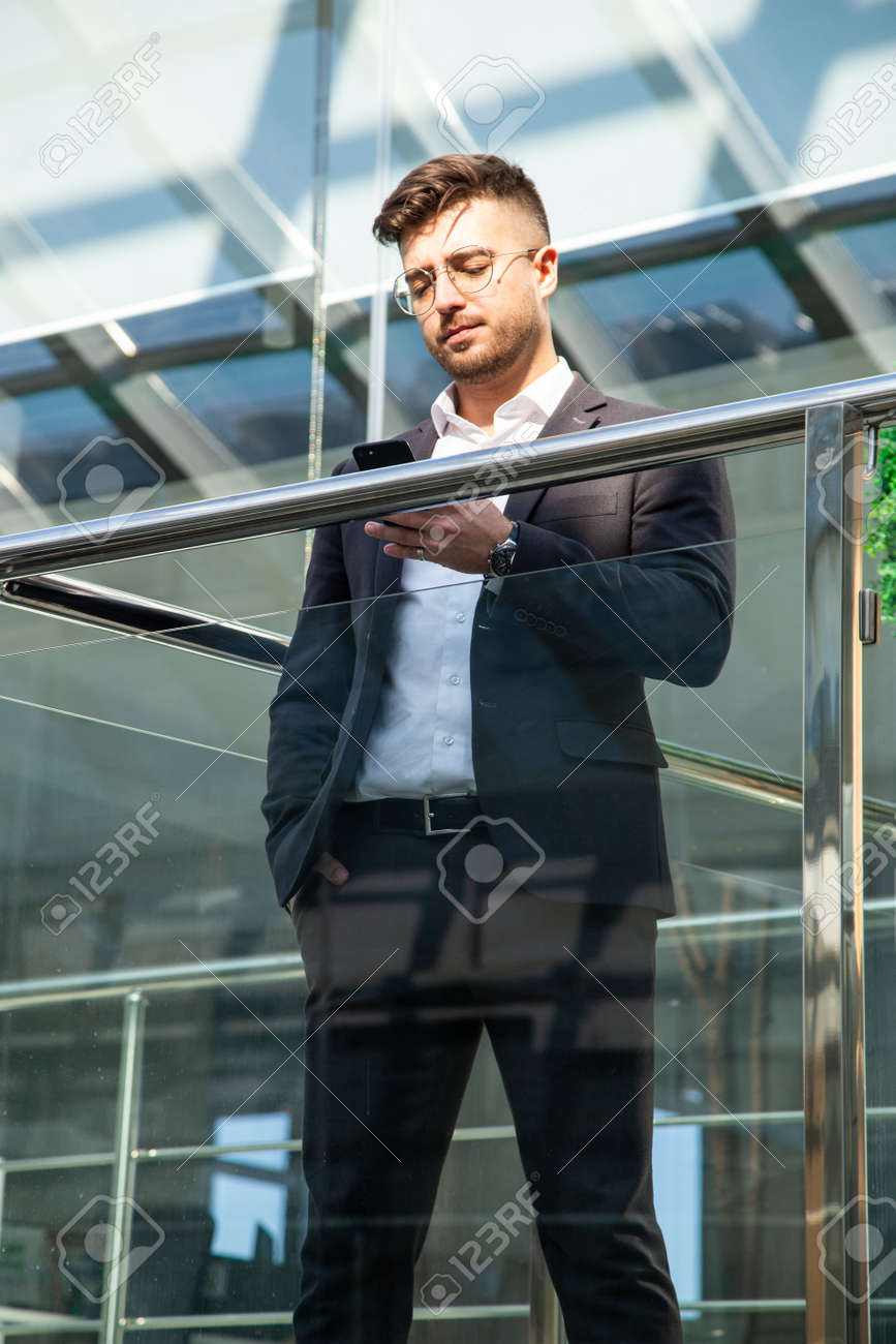 Portrait of a businessman in suit are standing on the background of glass offices. - 171660357 Portrait of a businessman in suit are standing on the background of glass offices. - 171660357