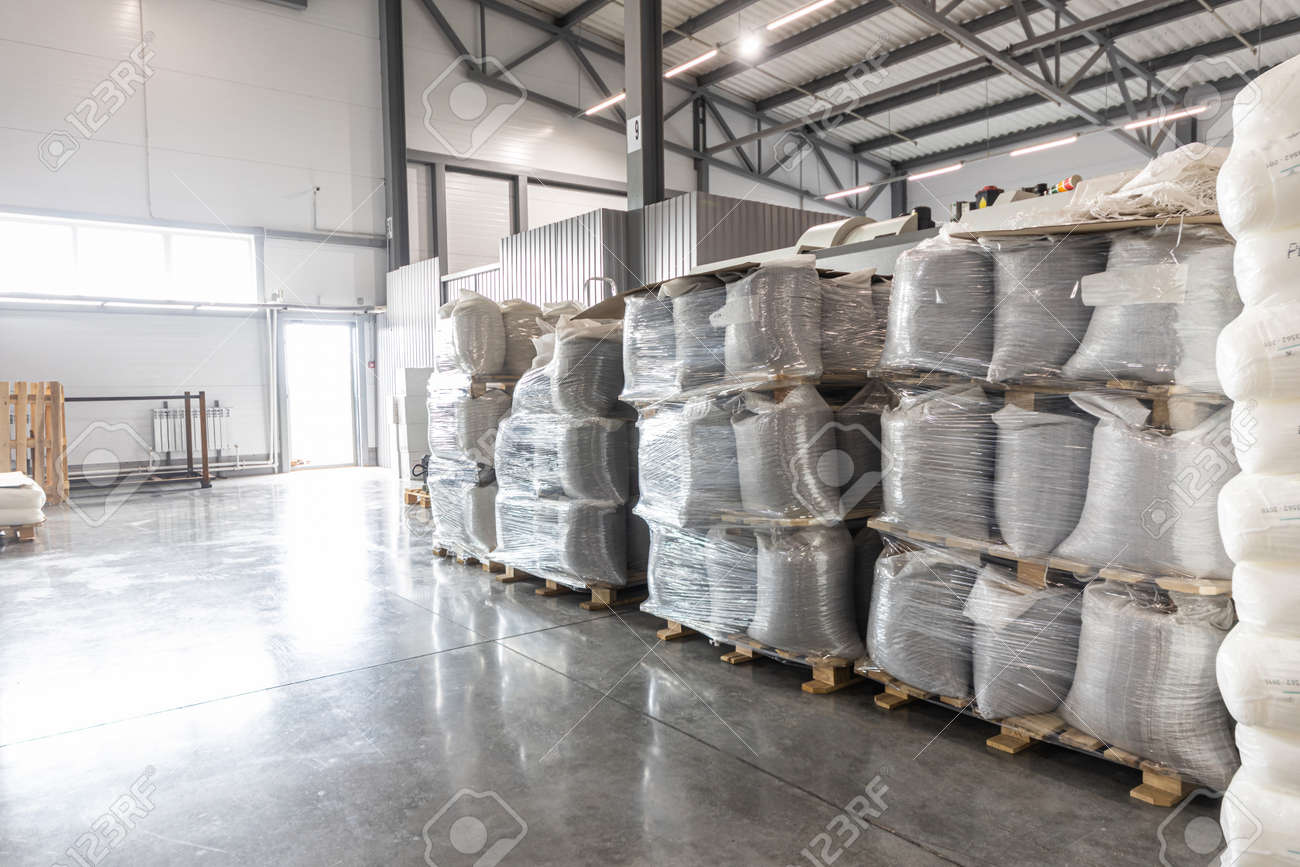 Spacious warehouse in a factory with special racks and shelves and products placed on them. - 171900114 Spacious warehouse in a factory with special racks and shelves and products placed on them. - 171900114