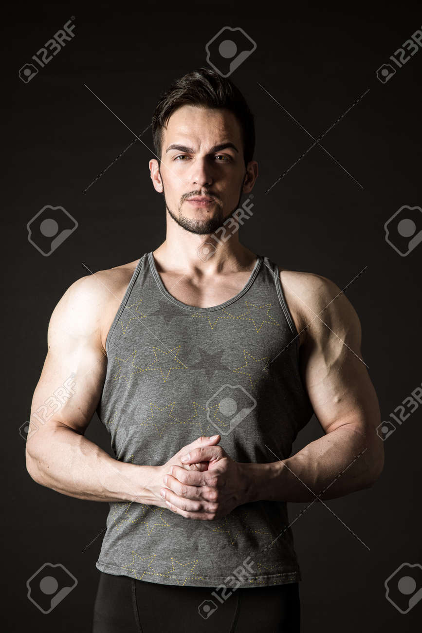 Awesome portrait of a handsome sporty model on a dark background - 171672553 Awesome portrait of a handsome sporty model on a dark background - 171672553