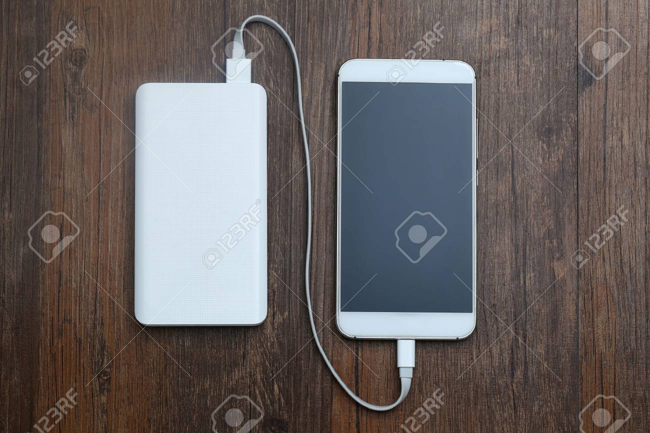 powerbank and cellphone on wooden table - 80548044 powerbank and cellphone on wooden table - 80548044