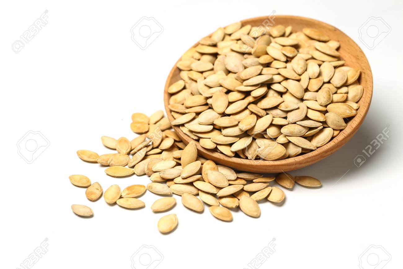 pumpkin seeds in wooden plate isolated on white background - 90369720 pumpkin seeds in wooden plate isolated on white background - 90369720