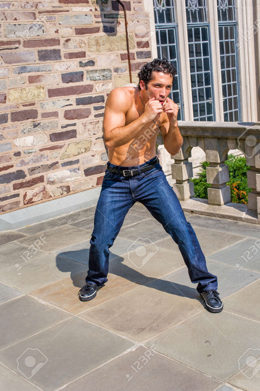 Dressing in jeans and leather sneakers and shirtless, a handsome, muscular guy is waving arms and exercising to counterattack - 170751268 Dressing in jeans and leather sneakers and shirtless, a handsome, muscular guy is waving arms and exercising to counterattack - 170751268