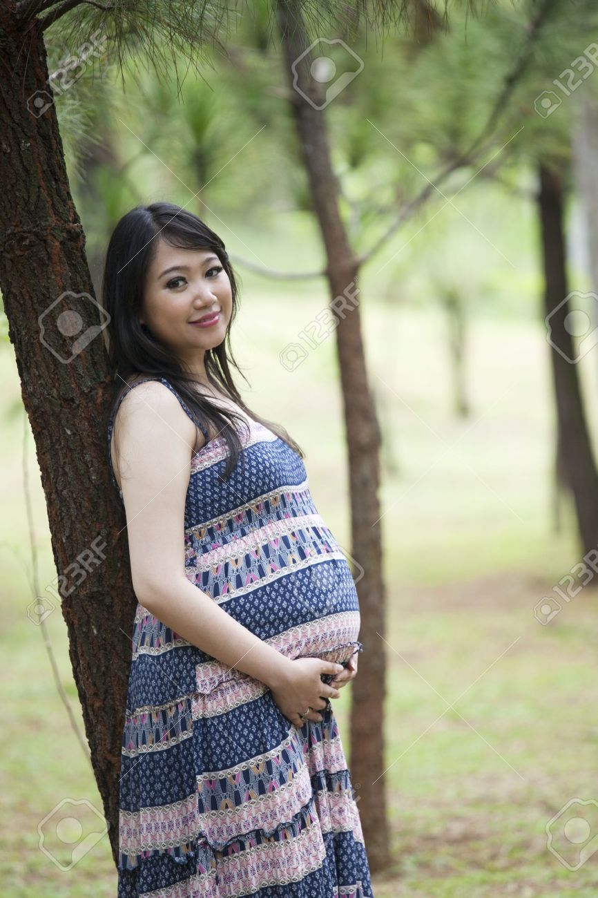 ツリーの下笑顔若い妊娠中の女性 の写真素材 画像素材 Image