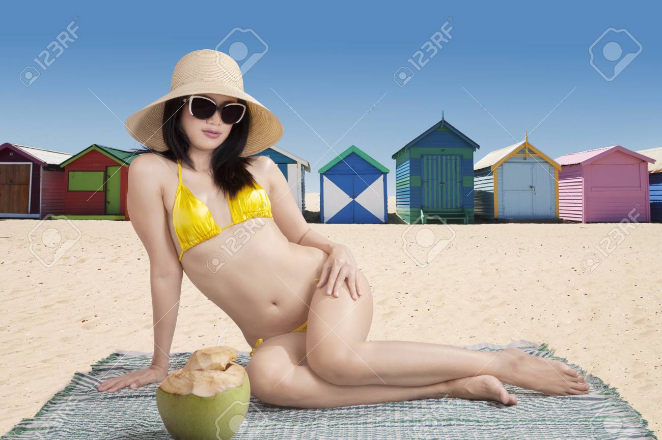 ブライトン ビーチ オーストラリアでアジアの女性の水着を着ていると ビーチの正面にマットの上に座っての家します の写真素材 画像素材 Image