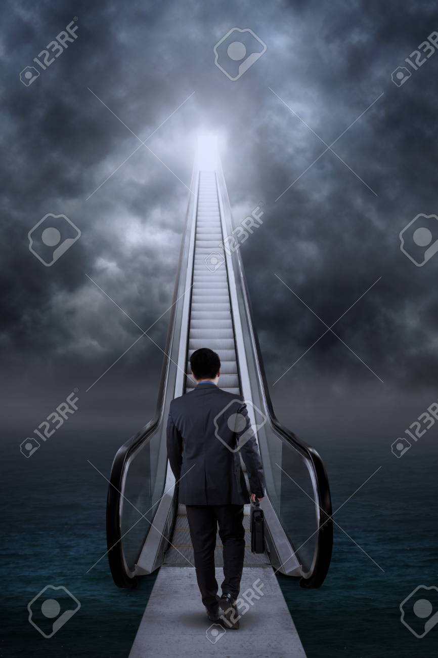 ビジネスマンの後姿を運ぶ ブリーフケースと空に希望の階段を登る の写真素材 画像素材 Image