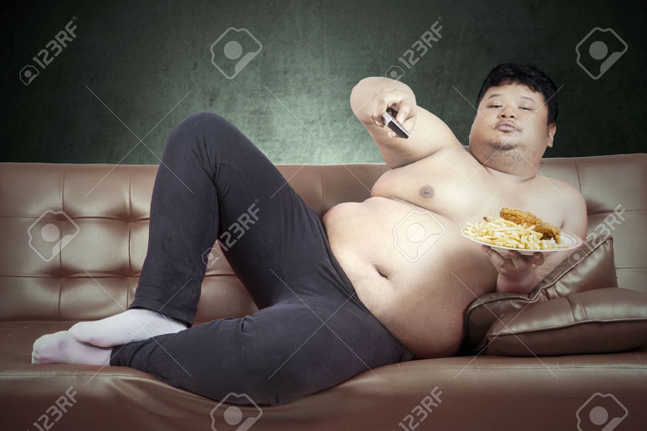 デブ男が自宅でテレビを見ながらファーストフードを食べる の写真素材 画像素材 Image