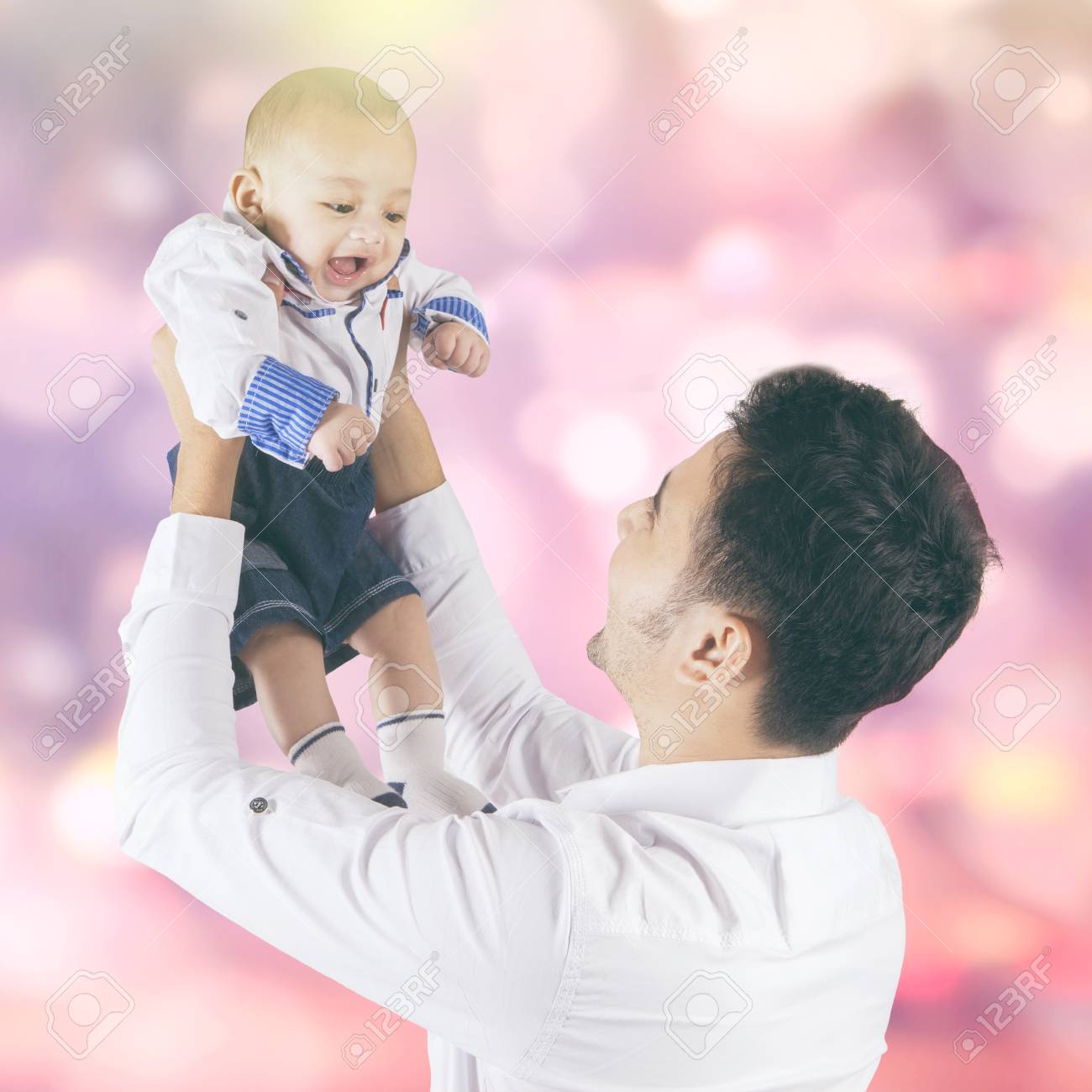 Portrait Of Happy Little Baby Boy Playing With His Dad Shot With Light Glitter Background Stock Photo Picture And Royalty Free Image Image
