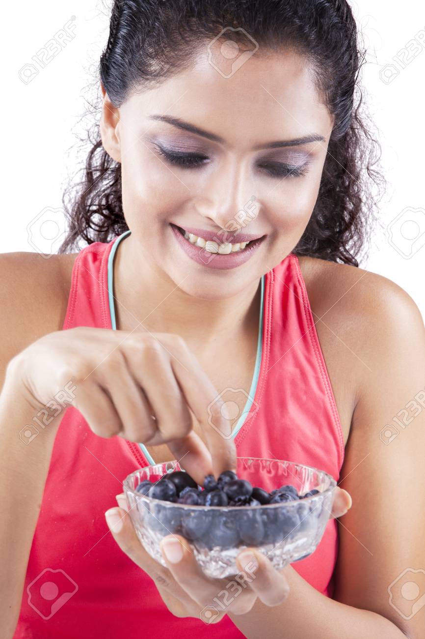 スポーツウェアを着用し 笑顔ながらボウルにブルーベリーを拾ってインド美人 の写真素材 画像素材 Image