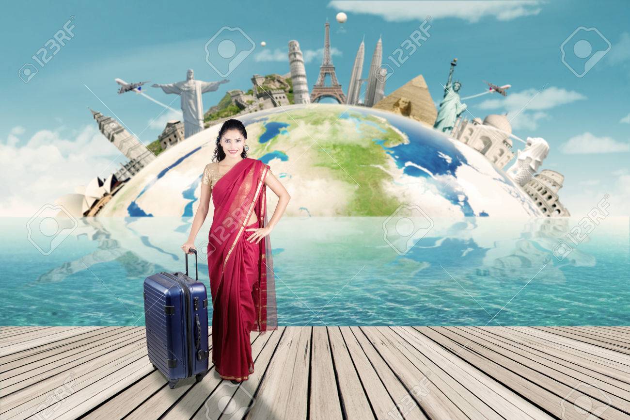 Beautiful indian woman carrying suitcase with map of world monument. Concept of travel around the world - 51606568 Beautiful indian woman carrying suitcase with map of world monument. Concept of travel around the world - 51606568