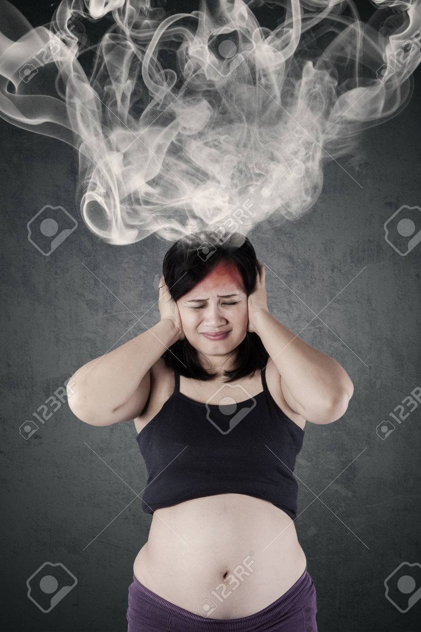 混乱を感じている彼女の頭から煙が出て爆発中ストレスの多い母の写真 の写真素材 画像素材 Image