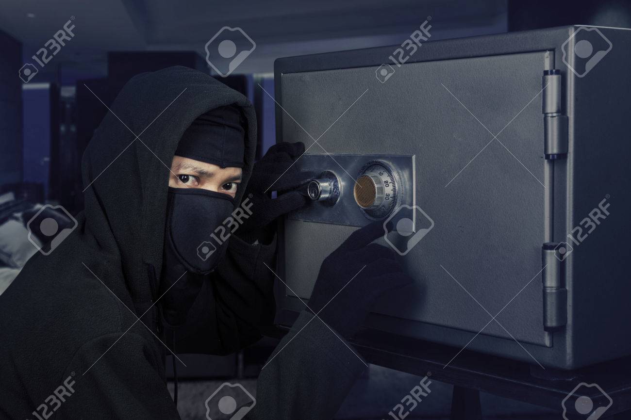 Male Burglar Wearing A Mask And Trying To Steal A Bank Vault In The Bedroom At Home Stock Photo Picture And Royalty Free Image Image 83141561