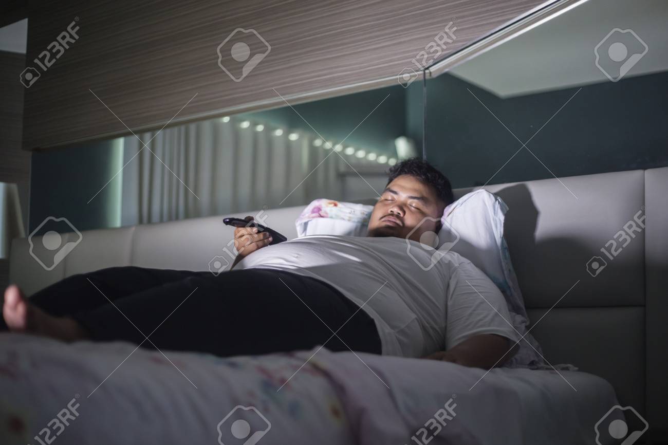 CREATIVA IMAGESPicture Of Young Fat Man Holding A