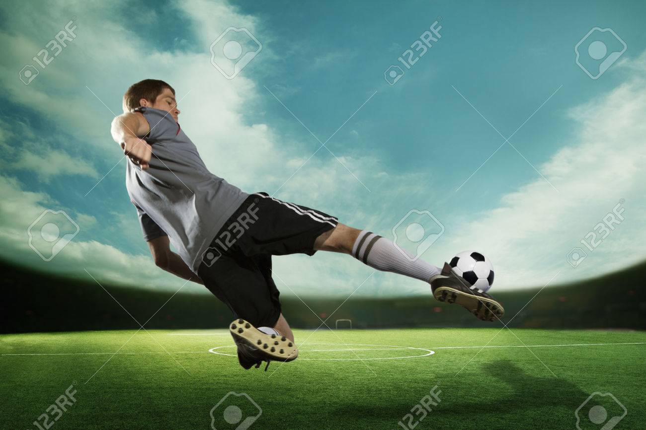 空とスタジアムで空中でサッカー ボールを蹴るサッカー選手 の写真素材 画像素材 Image