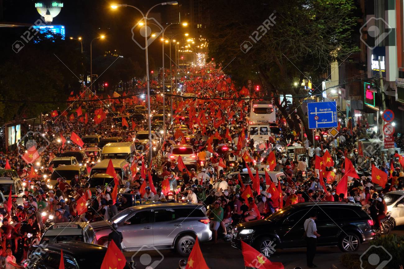 ホーチミン市 Viet Nam Jan 24 18 U23ベトナムとu23カタールの間のサッカーの後の勝利を祝うために道を下るベトナムのサッカーサポーターの群衆 ファンからの赤い旗で高い視野 の写真素材 画像素材 Image