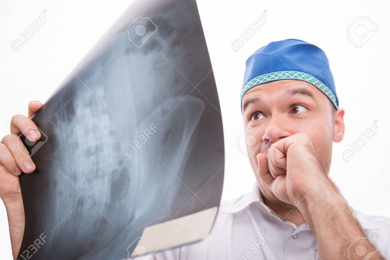 白いシャツと レントゲン写真を見て青いキャップを身に着けている非常に驚いて外科医の半身像 白い背景に分離 の写真素材 画像素材 Image