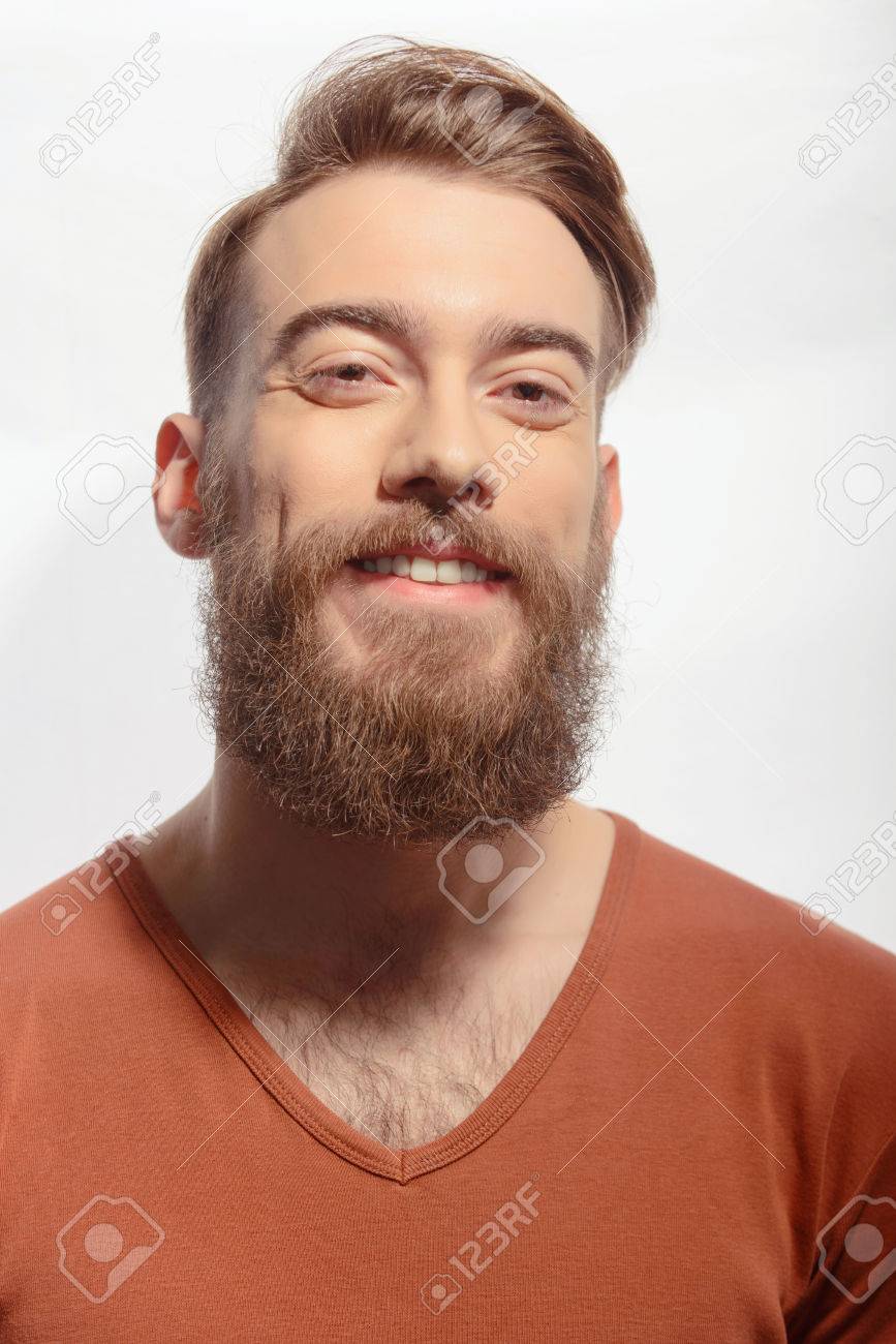 ひげとトレンディな オレンジ色の T シャツを着て 白い背景に 立ったままカメラで笑顔のハンサムな髭の男のポートレート クローズ アップ の写真素材 画像素材 Image