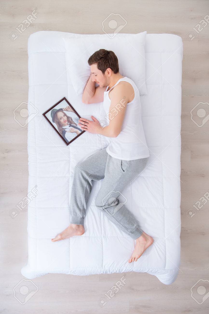 私の夢をみましょう 彼の恋人の肖像画を睡眠中にベッドで横になっている気持ちのいい男のトップ ビュー の写真素材 画像素材 Image