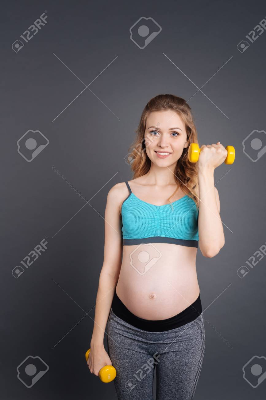J'aime Fitness. Jolie Jeune Femme Enceinte De Levage Haltères Jaunes Dans  La Salle De Gym Exprimer Positivité Banque D'images Et Photos Libres De  Droits. Image 66318919.